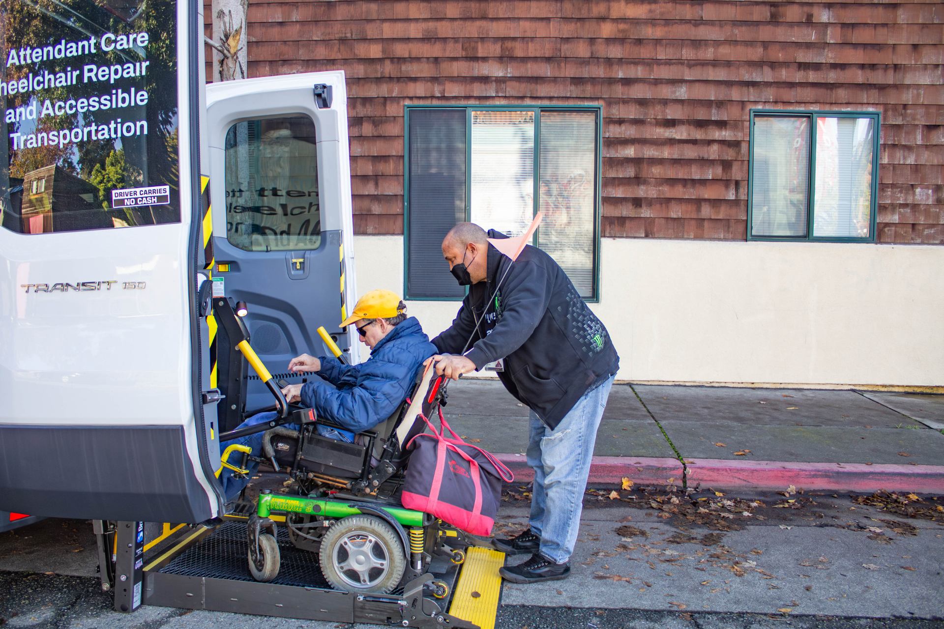 Driver, Drew, helps a client board one of our accessible transportation vans.