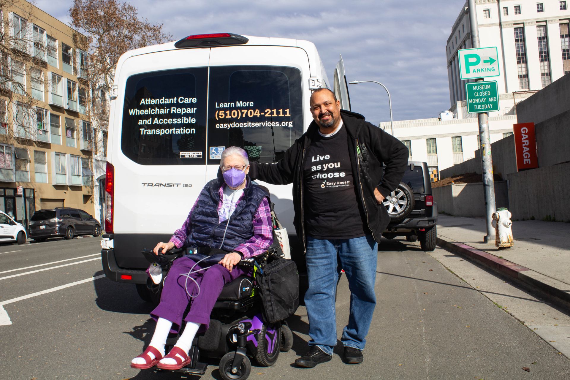 Drew poses for a photo with one of his clients in front of the Oakland Museum.