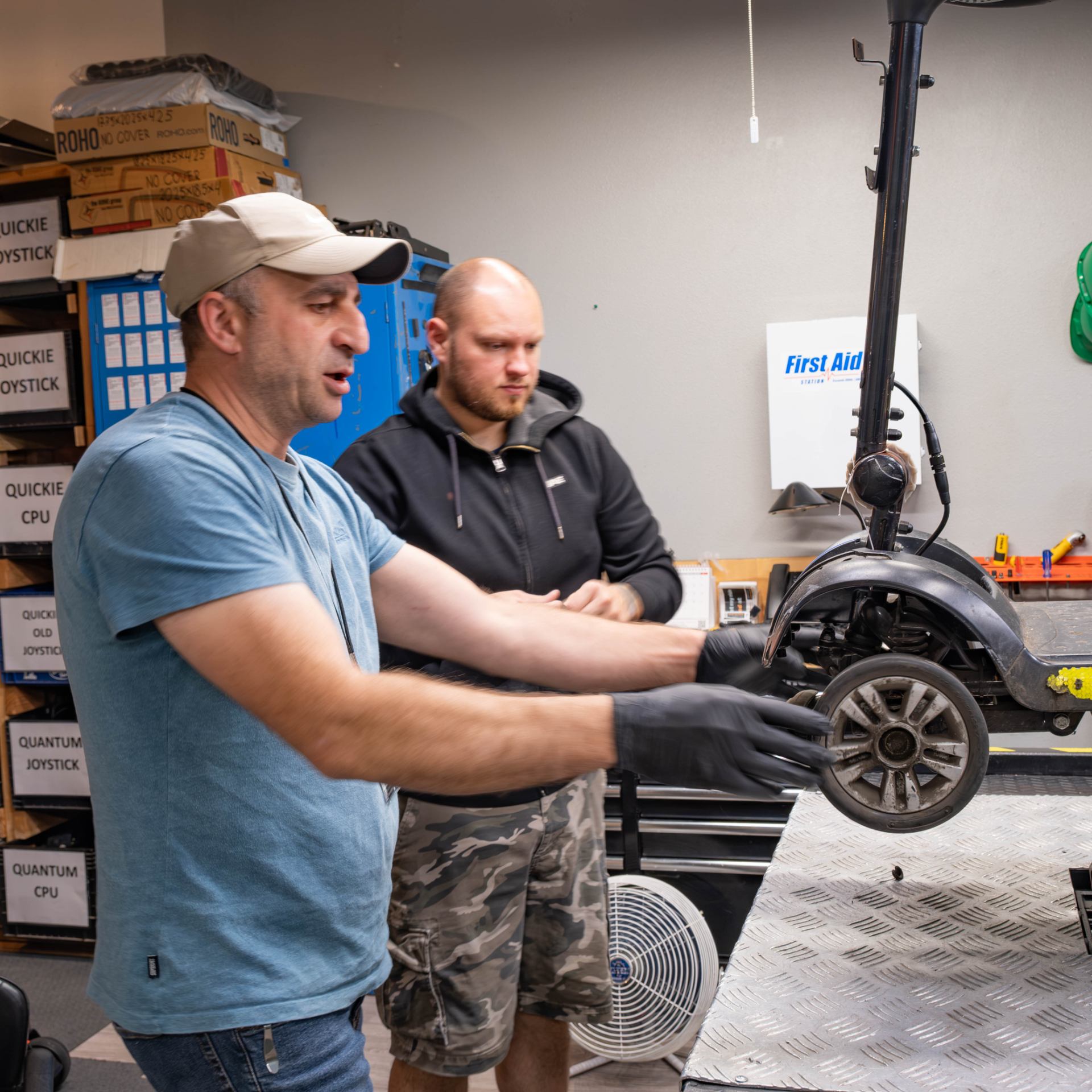 Levan and Chris inspecting the wheels on a donated power chair.